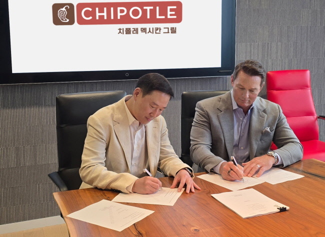 스캇 보트라이트(Scott Boatwright) 치폴레 멕시칸 그릴 CEO(오른쪽)와 허희수 SPC그룹 부사장이 한국 및 싱가포르의 치폴레 사업 운영을 위한 합작법인 설립 계약서에 서명하고 있다.(사진=SPC그룹 제공)