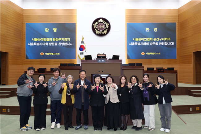 김영옥 위원장이 농아인들과 함께 수어로 “사랑한다”는 제스처를 취하고 있다.(사진=서울시의회 제공)