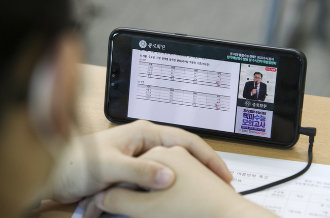 &nbsp;지난 7월 24일 서울 양천구 목동종로학원에서 학생들이 휴대폰으로 비대면으로 열린 2022수시 최종지원전략 설명회를 보고있다.(사진=뉴시스 제공)&nbsp;